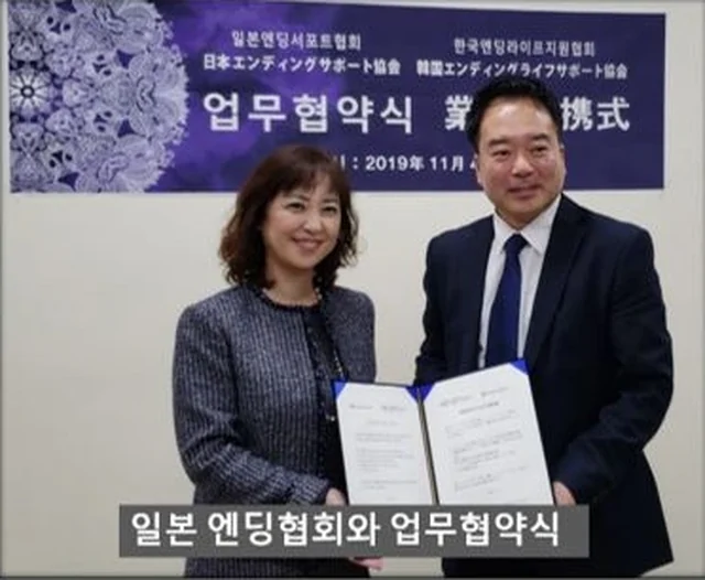 일본 엔딩협회와 업무 협약식에서 협약서를 든 두 사람